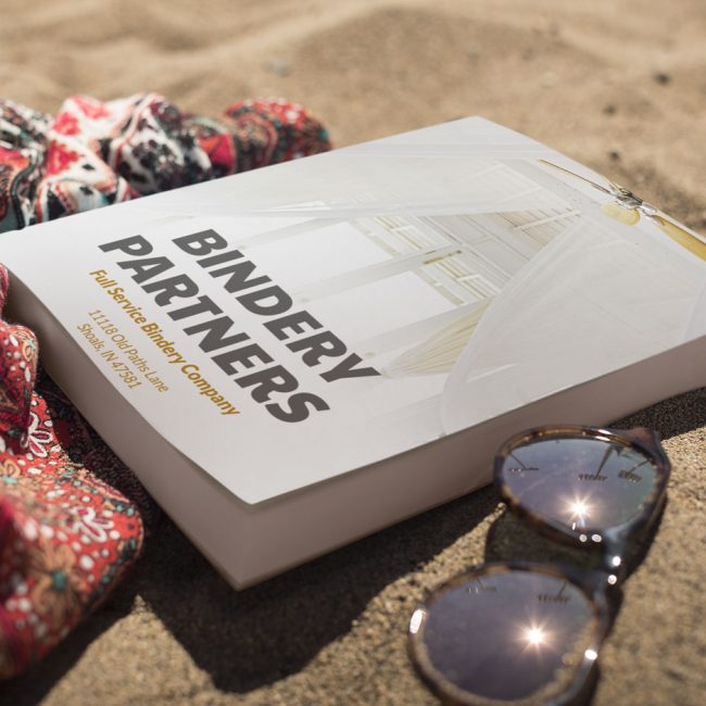 Perfect-Binding-Bound-Service-book-lying-on-the-beach-Commercial-Binding-Service